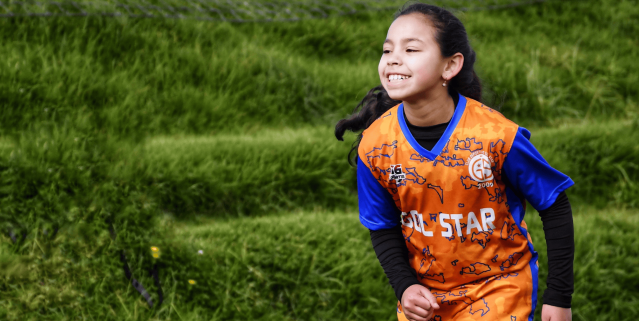 Soccer player smiling and running